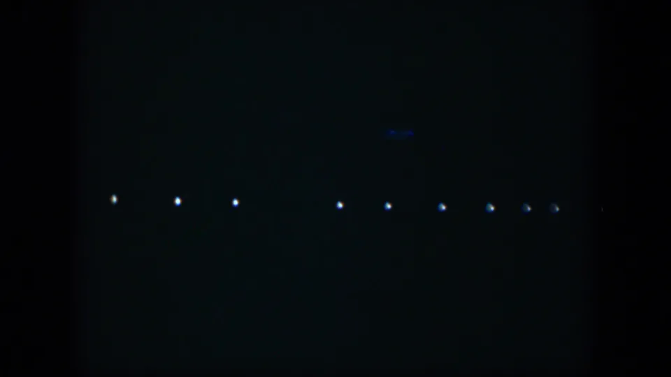 1951 Cuba 8mm frame with distant white points stretching horizontally through a dark night view.