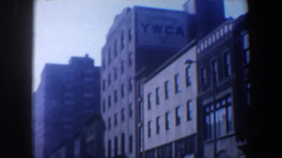 1962 Philadelphia street frame with a prominent YWCA sign on a multi-story building and nearby urban facades.