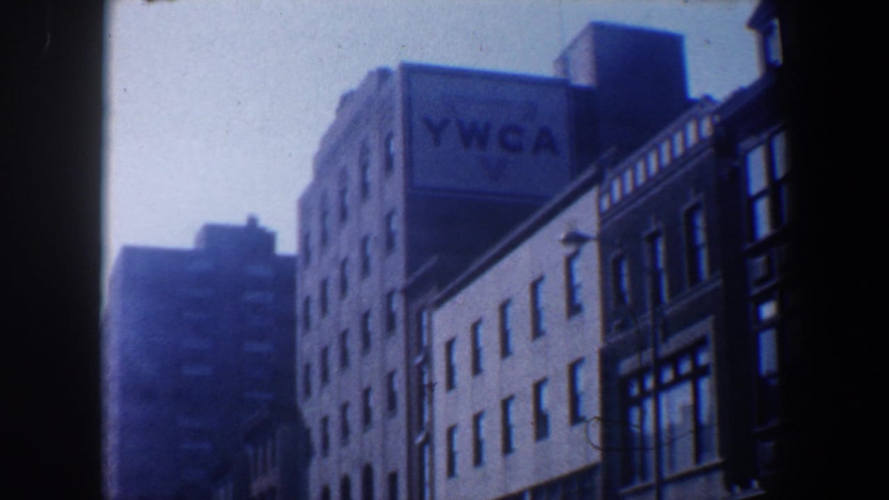 1962 Philadelphia street view from a moving vehicle, showing a multi-story YWCA building and neighboring urban facades.