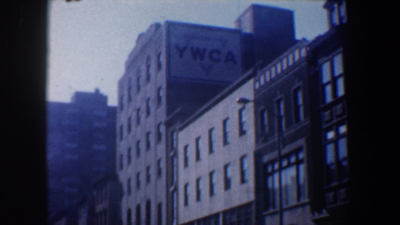 YWCA building and neighboring storefront facades seen through soft 8mm blur.