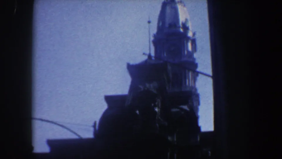 1962 Philadelphia home-movie frame of an ornate tower silhouette, with its upper structure set against a blue sky.