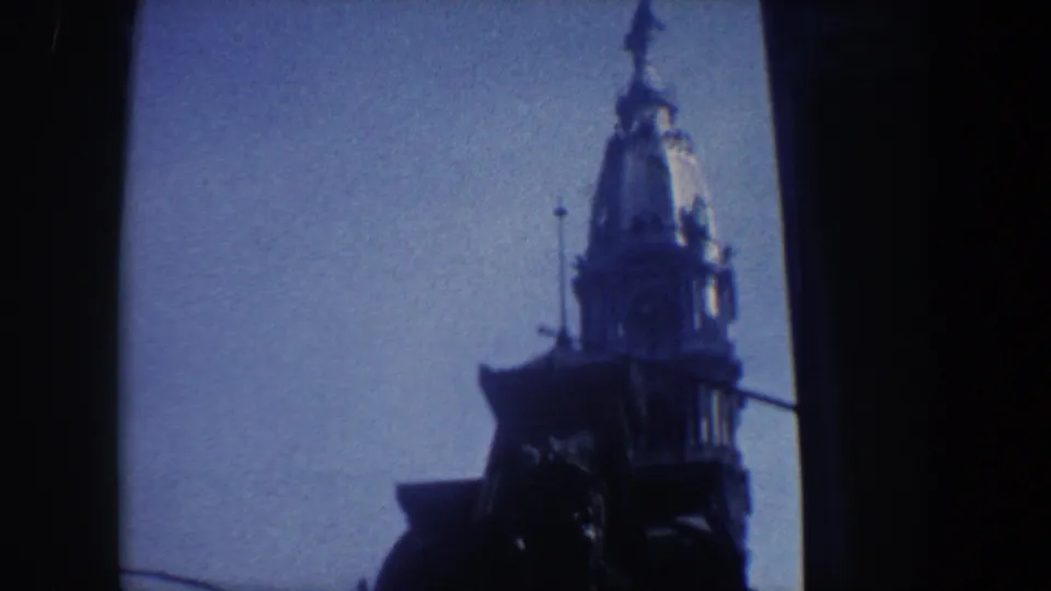 Late frame from a 1962 Philadelphia 8mm shot, showing the tower and spire in silhouette against blue sky.