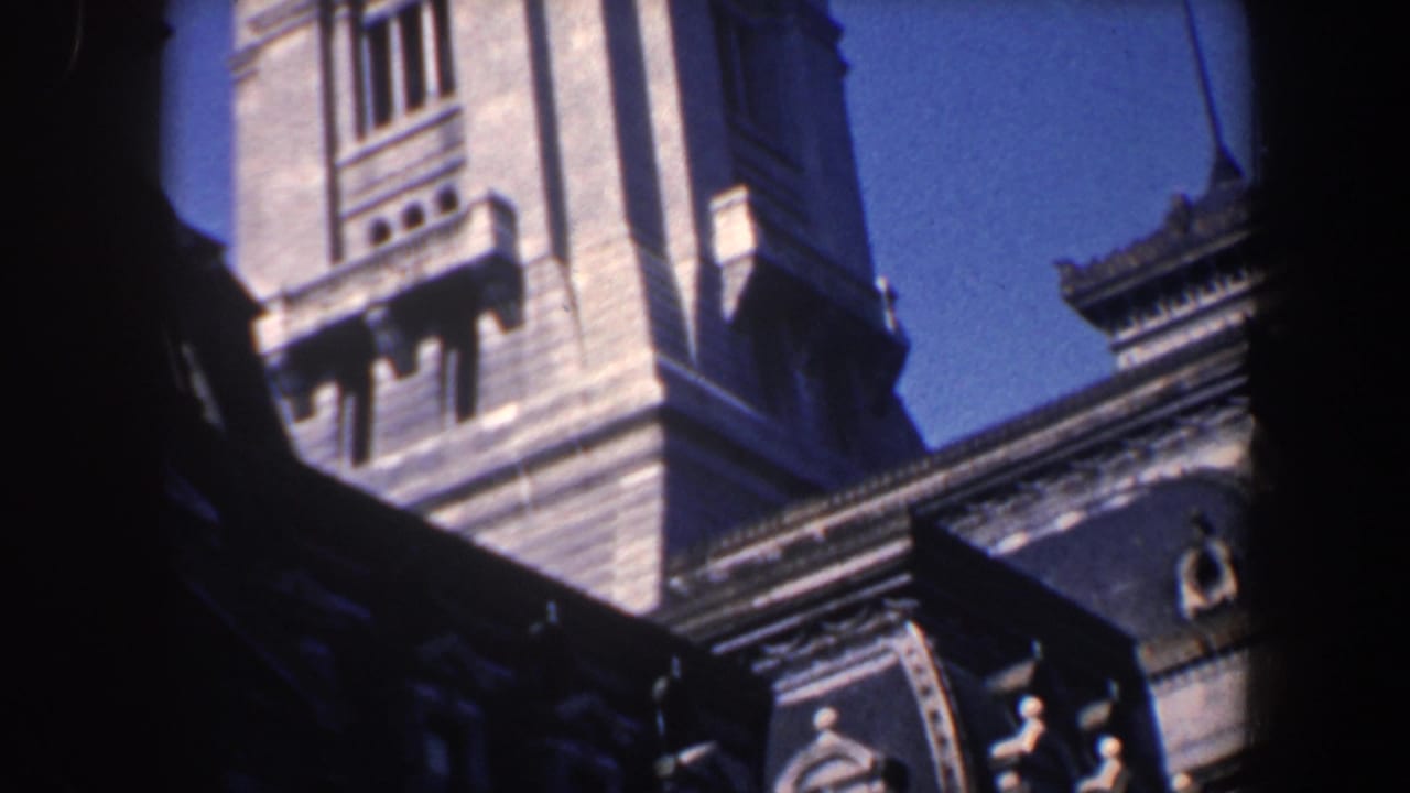 Ornate stone towers and roofline seen against a blue sky with dark foreground framing.