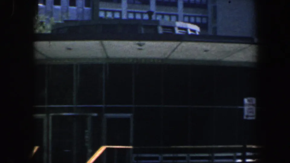 Philadelphia 1962 frame with the public hall entrance partly obscured by dark vertical framing, showing glass doors, canopy underside, steps, and railings.