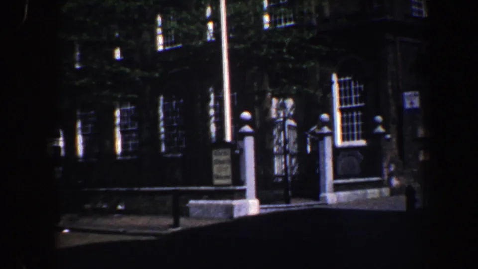Philadelphia church facade with iron fencing, white posts, flagpole, ivy, and a visitor sign visible in 1962 footage.