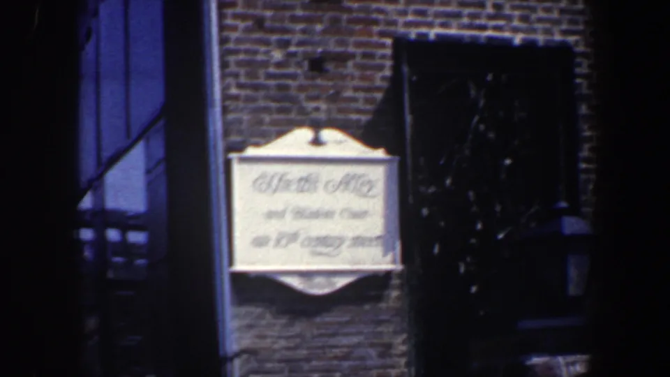 Home-movie view of the Smiths Alley and Belden Court sign on a Philadelphia brick facade in 1962.
