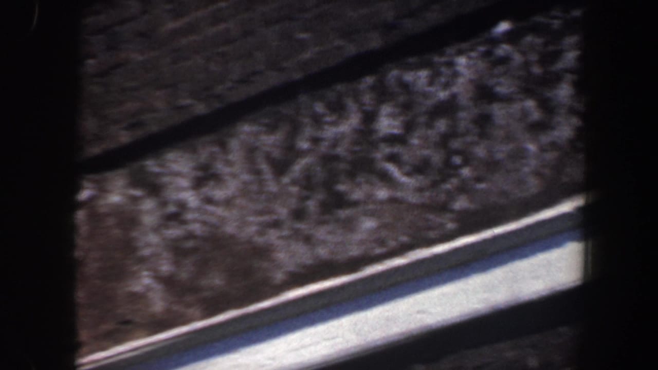 Close view of brick roofline, wall, and white trim in soft 8mm footage.