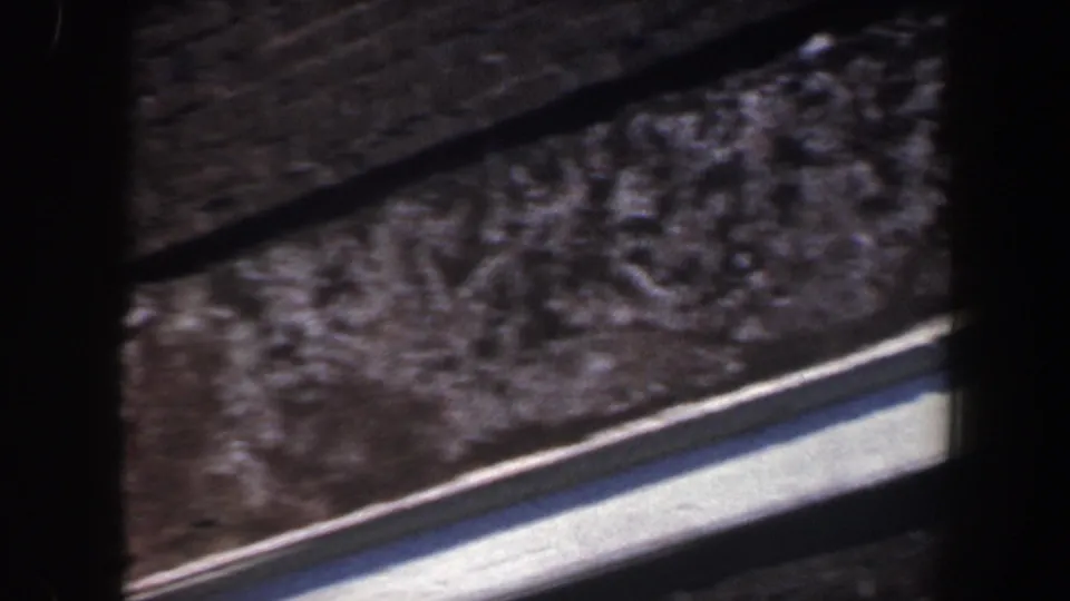 1962 Philadelphia 8mm frame showing a close pan across brick building edges, roofline texture, and white exterior trim.