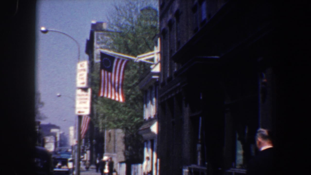 Flag on a building facade with a man partly visible at the right edge of the street scene.