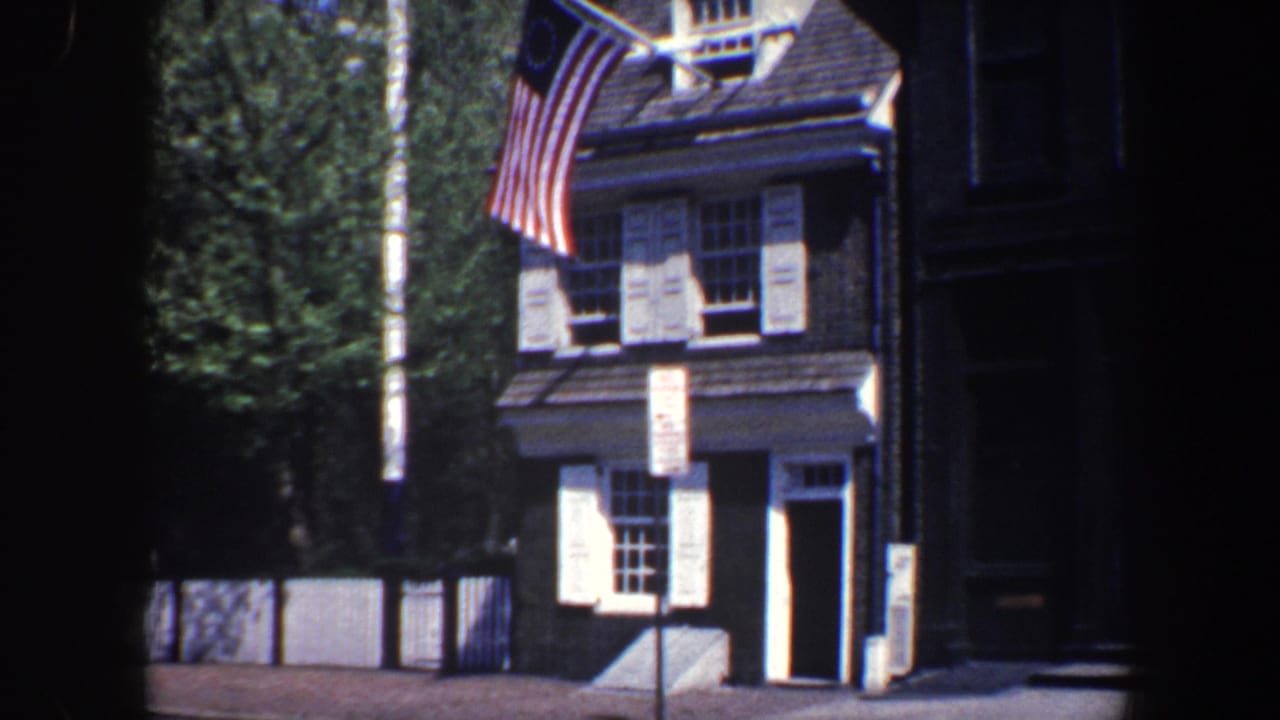 Brick colonial-style building with white shutters and a Betsy Ross-style flag above the roof.