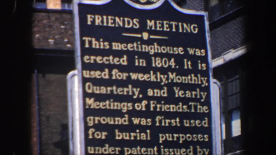 Final close view of the Friends Meeting marker in 1962 Philadelphia, with the sign text and neighboring brick architecture visible.