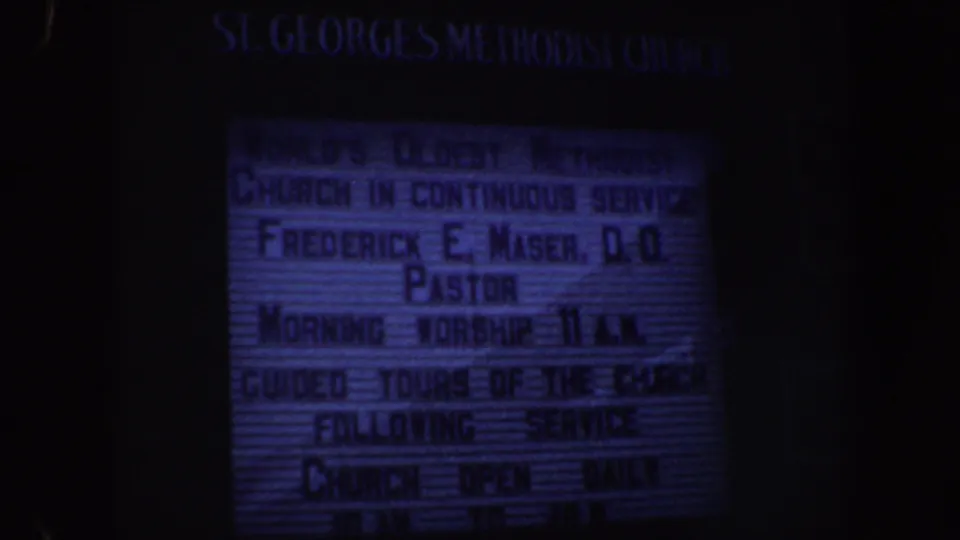 St. George's Methodist Church marquee appears in a low-light 1962 Philadelphia home-movie frame with soft focus and blue color cast.
