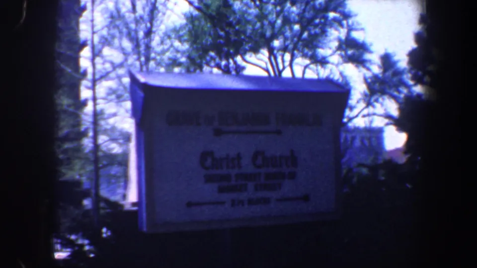 Philadelphia landmark sign for Christ Church and the grave of Benjamin Franklin, filmed outdoors in a blue-tinted 8mm frame.