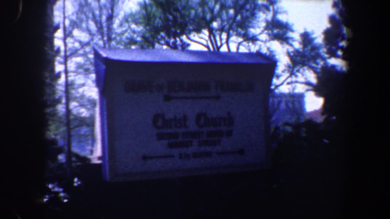 Directional sign for Benjamin Franklin's grave and Christ Church beside trees.