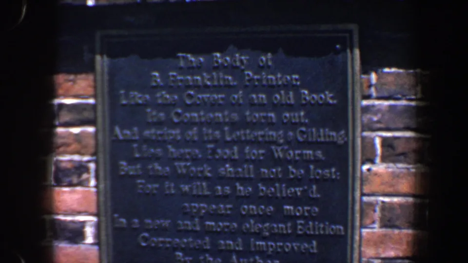 A dark Benjamin Franklin-related plaque on a brick wall appears in the 1962 Philadelphia home-movie pan.