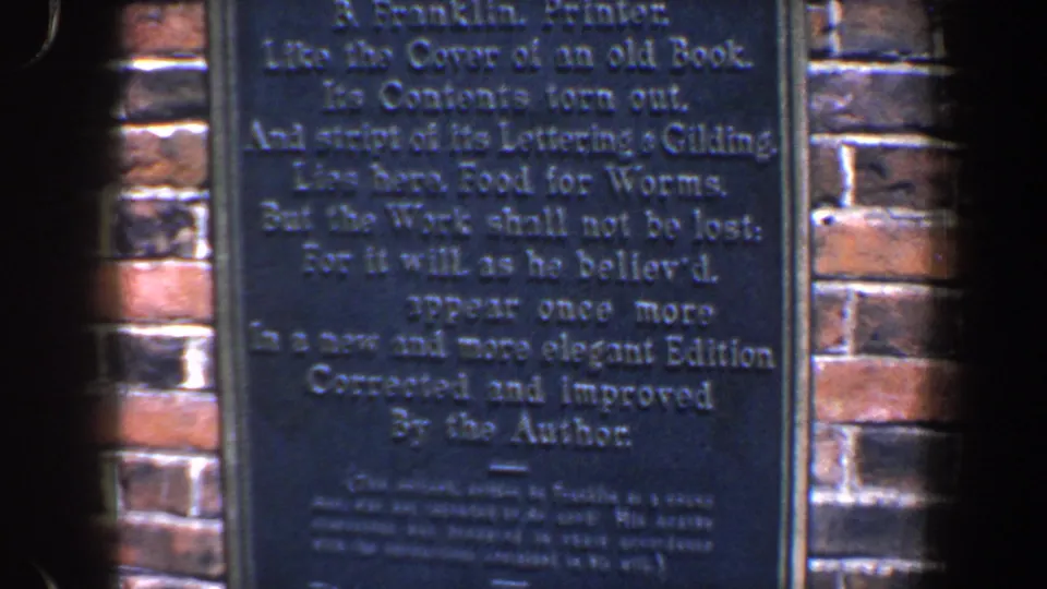 The plaque text remains centered in a handheld 1962 Philadelphia view, with brick courses visible along both sides.