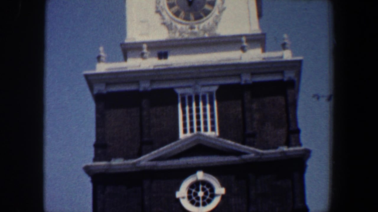 Clock tower and dark facade with circular window below.