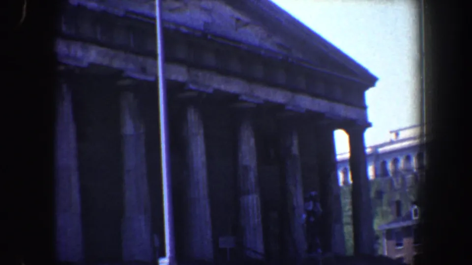 1962 Philadelphia home-movie frame showing the upper facade, columns, steps, streetlight, and nearby buildings.