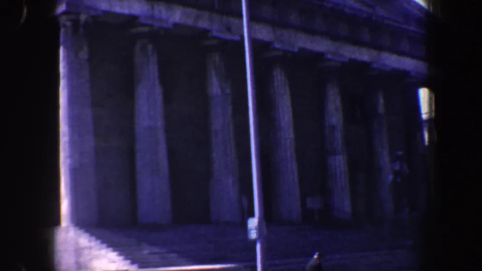 1962 Philadelphia footage frames the building's tall stone columns, shaded entrance area, steps, and streetlamp from across the street.