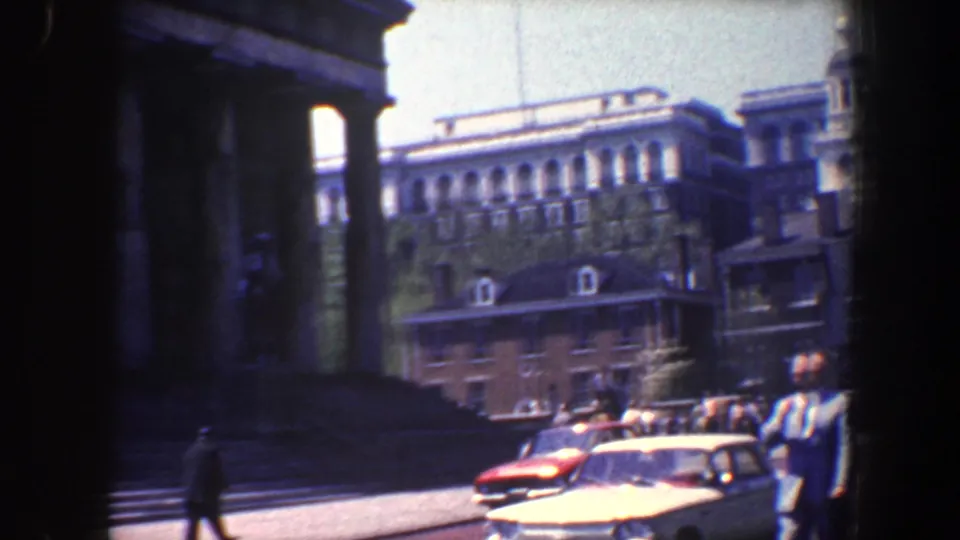 The final 1962 Philadelphia frame shows pedestrians and mid-century cars passing near a large columned building and older urban buildings.