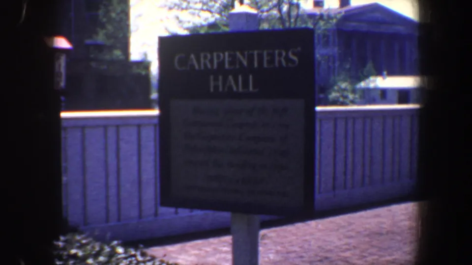 Close 1962 Philadelphia view of the Carpenters' Hall sign, with brick paving and fence visible behind.