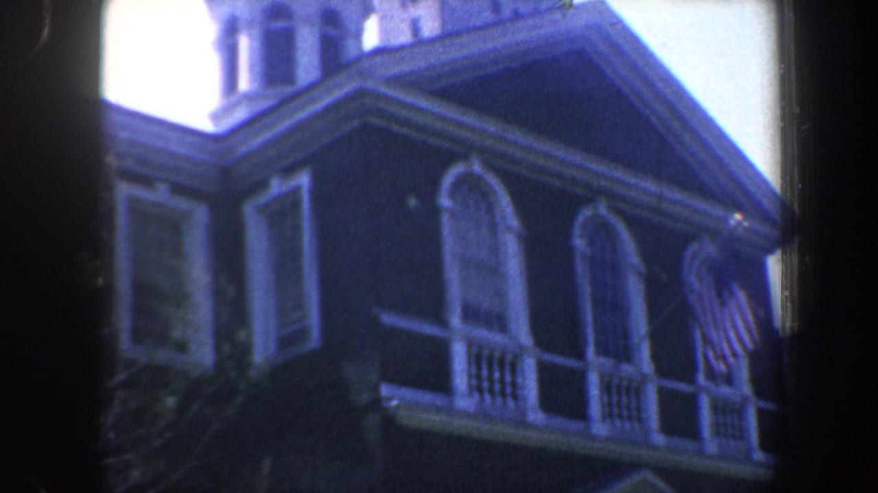 1962 Philadelphia 8mm frame showing the upper facade of a historic public building with arched windows, roofline, and partial dome.
