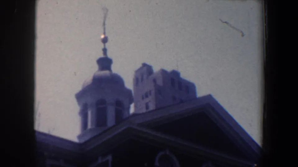 1962 Philadelphia frame focused on the cupola and upper roofline of the public building, with a taller structure behind it.