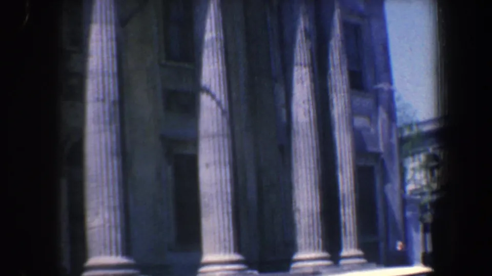 1962 Philadelphia home-movie view of tall columns and steps, with a lamppost and adjacent street detail visible at the right edge.