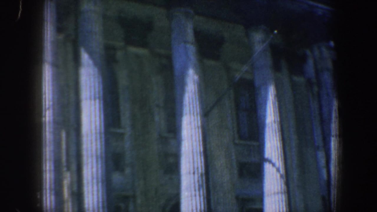 1962 Philadelphia home-movie frame showing fluted stone columns and shadowed facade openings on a classical building.