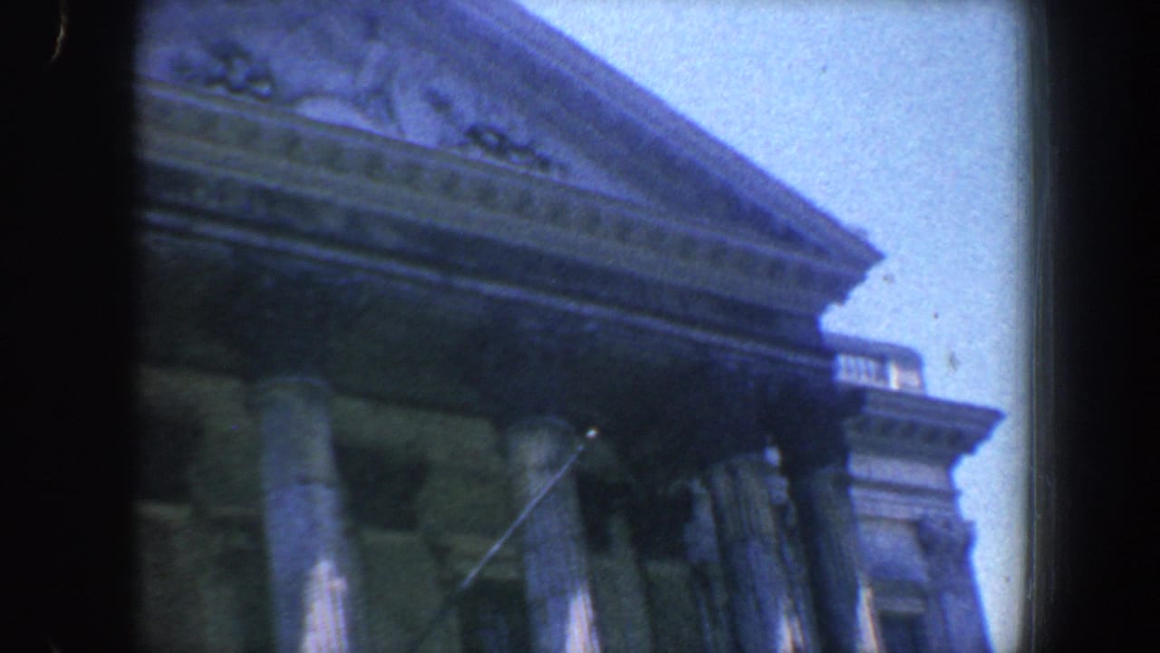 1962 Philadelphia 8mm frame showing a partial classical building facade, columns, blue cast, and heavy dark frame edge.