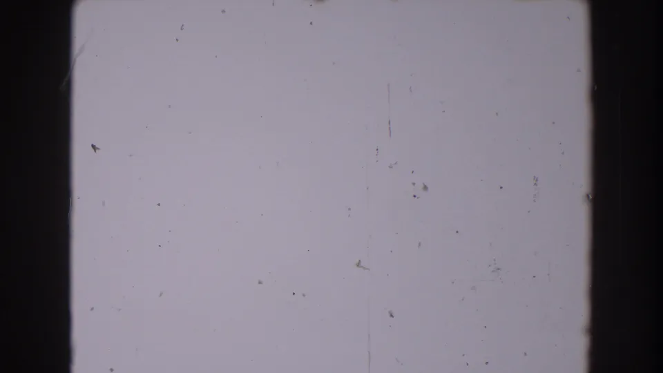 Light gray 8mm blank frame area with dark gate edges, scattered dust, scratches, and grain from the 1962 North Hollywood source reel.