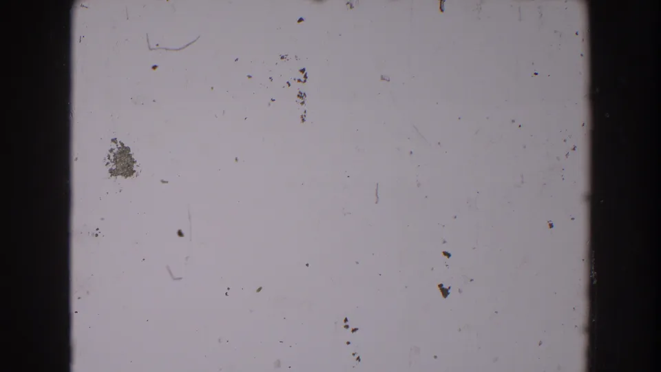 Blank 8mm frame from the supplied 1962 North Hollywood footage, showing pale film, black borders, dust specks, scratches, debris, and grain.