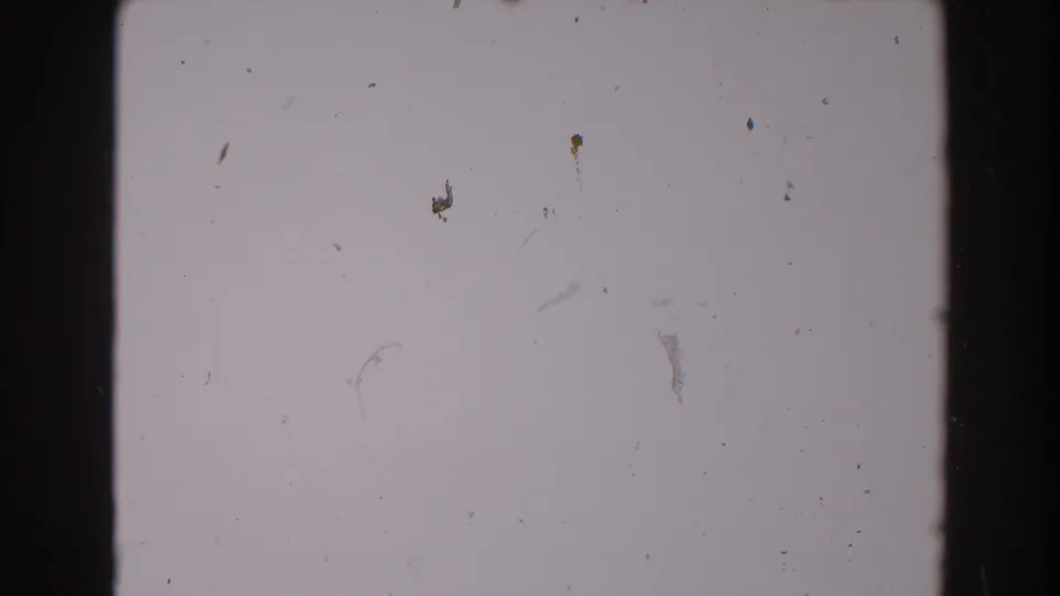 Blank 1962 8mm film frame from the North Hollywood reel, showing pale exposure, dark gate edges, dust, and fine scratches.