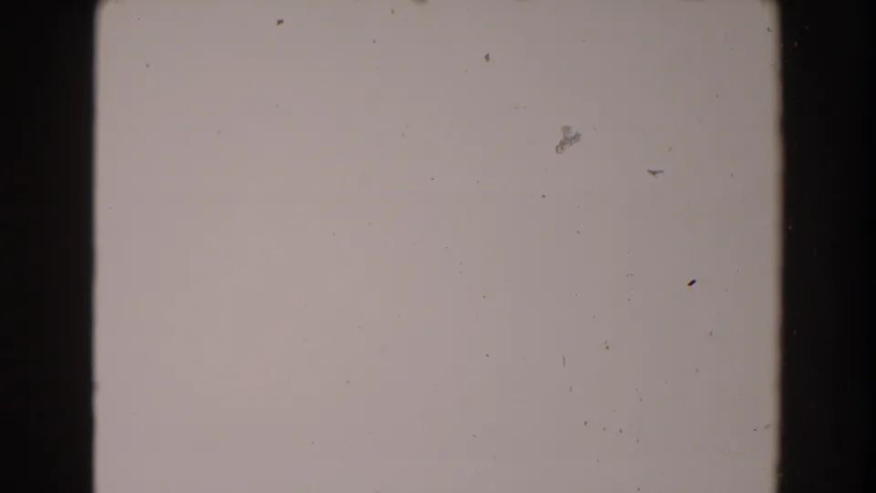 Blank-looking 8mm frame from the supplied 1962 North Hollywood clip, with a central border, dust, and soft exposure variation.