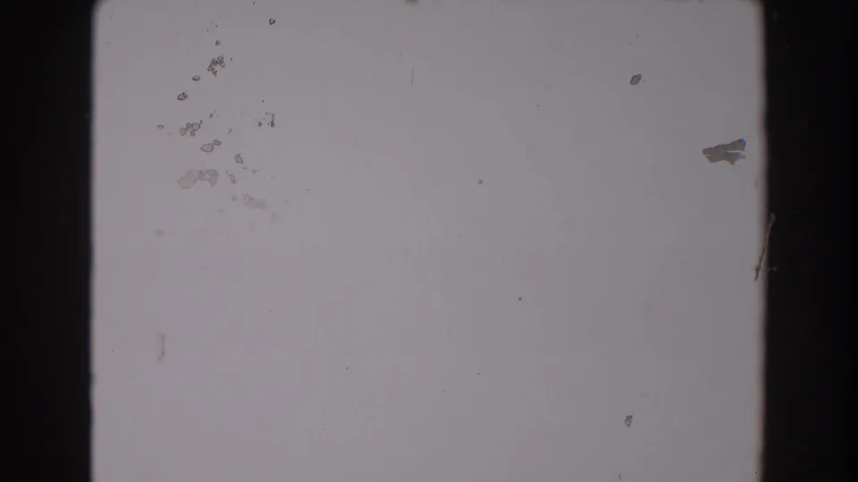 1962 North Hollywood 8mm frame showing an overexposed blank area with black film edge, dust, and small scratches.