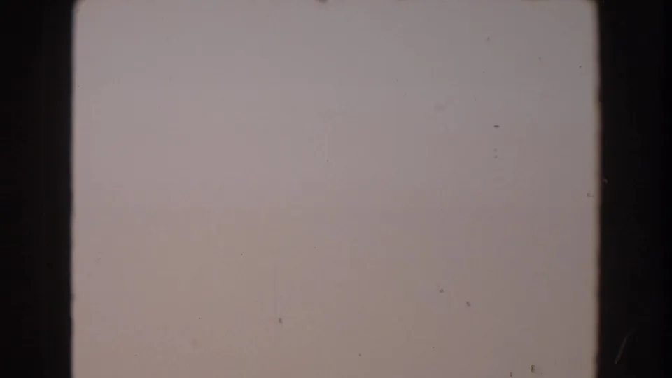 1962 North Hollywood 8mm frame with a pale overexposed surface, subtle grain, dust specks, and edge darkness.