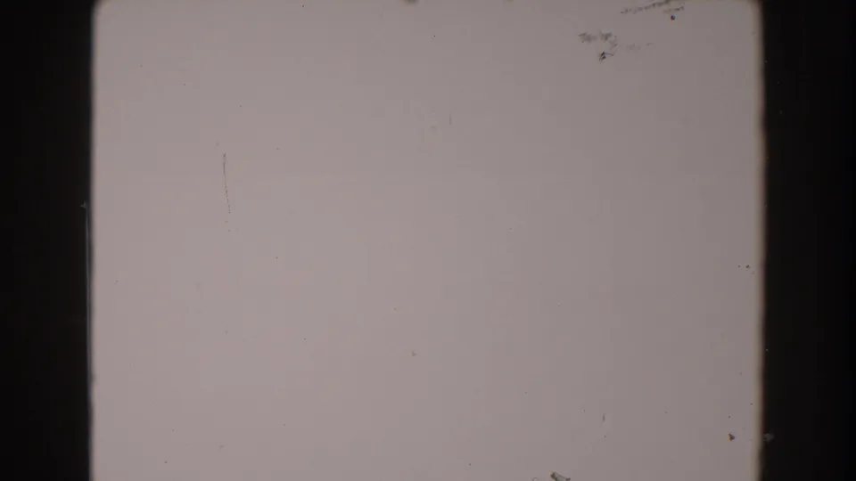 1962 North Hollywood 8mm home-movie frame showing blank pale film area with dark edges, dust specks, and light scratches.