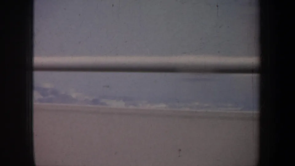 San Francisco-area 8mm travel view with window framing over water, pale shore, and low distant landforms.