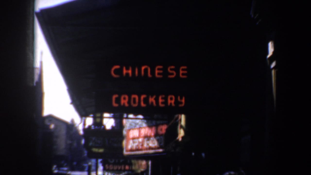 Red Chinese crockery sign seen from a darker angle under an awning.