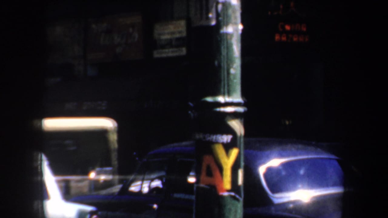 Dark San Francisco street with parked vintage cars and a foreground utility pole.