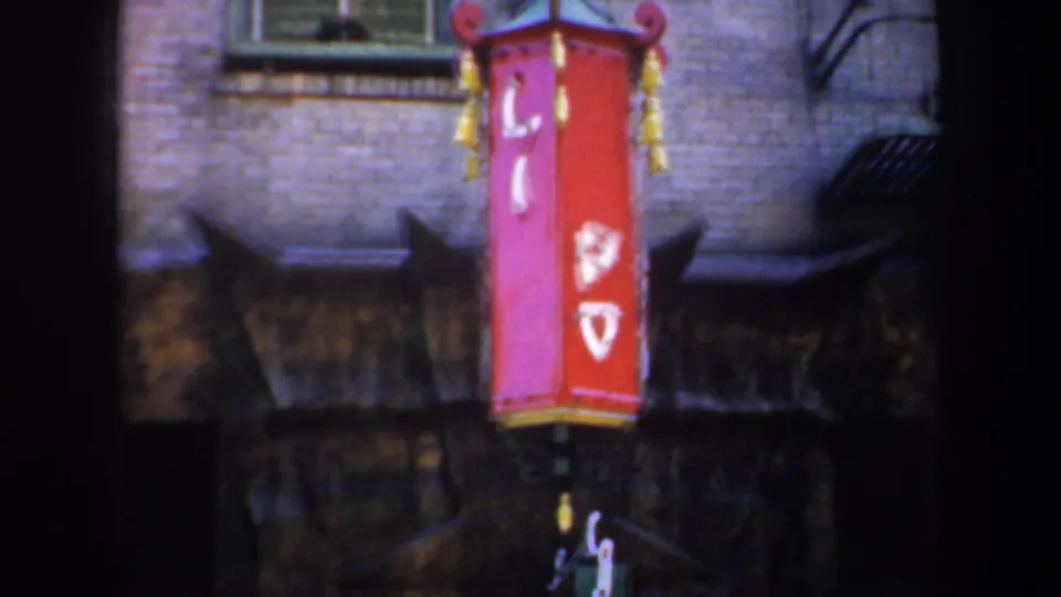 Close view of a red Chinese-style lantern on a brick facade in 1957 San Francisco Chinatown footage.