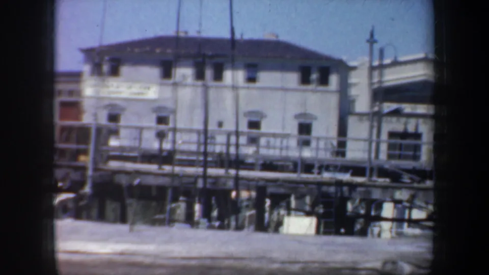 San Francisco waterfront structure appears through soft 8mm framing, with railings, windows, and pier supports visible.