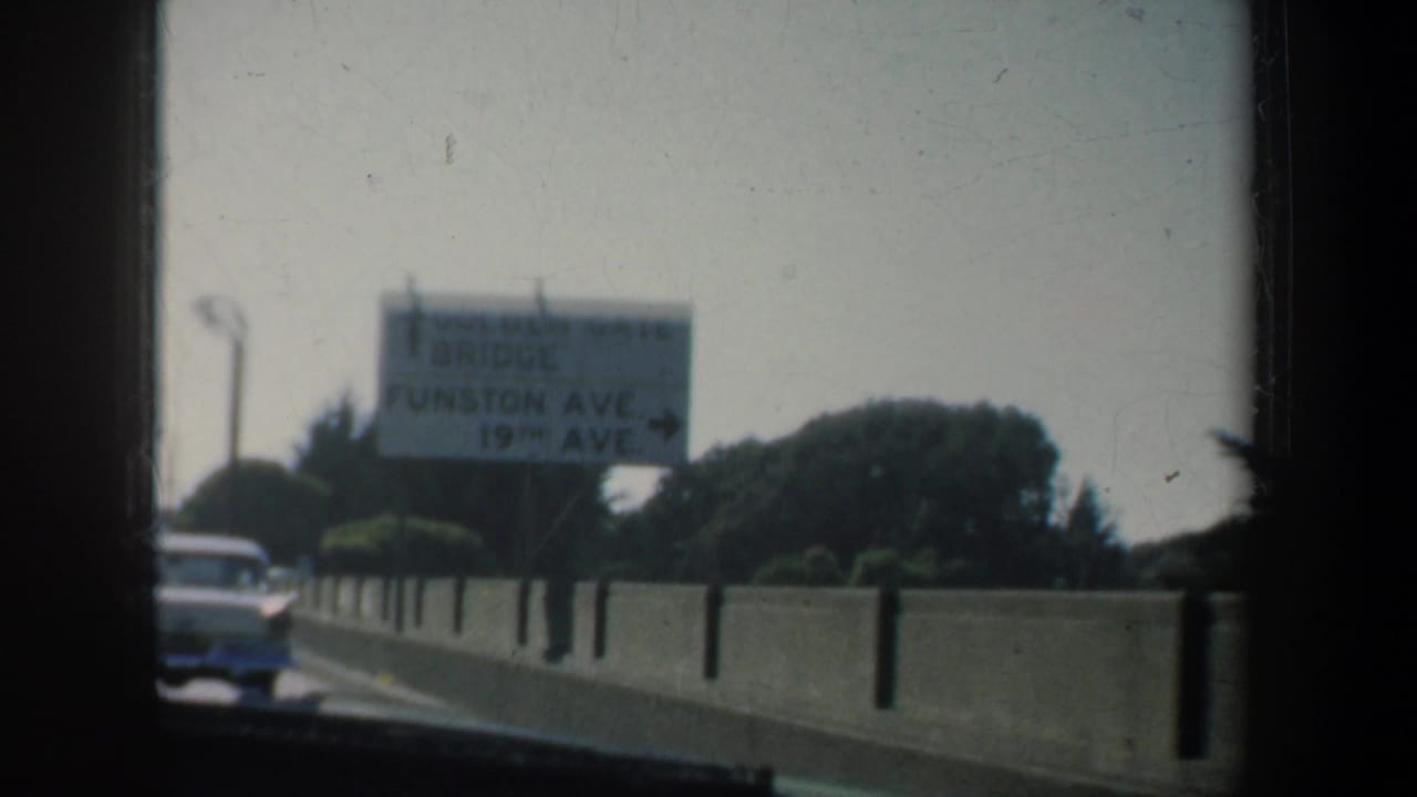 1957 8mm San Francisco road-trip frame with a roadside sign partly legible for Funston Ave. and 19th Ave.