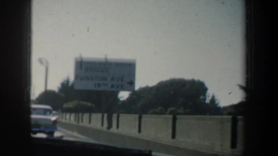 1957 8mm San Francisco road-trip frame with a roadside sign partly legible for Funston Ave. and 19th Ave.