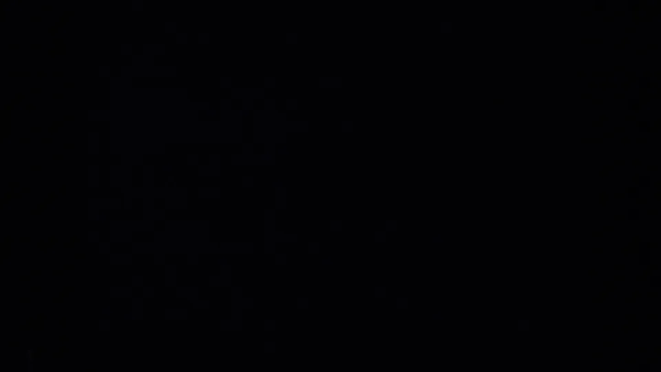 Dark 1957 8mm frame from the San Francisco reel, showing only faint texture and indistinct shadowing.