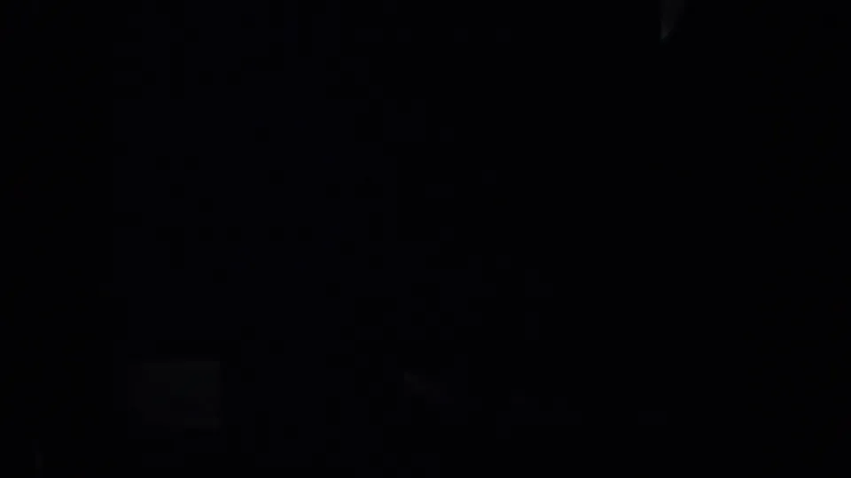 A very dark 1957 San Francisco 8mm frame showing dim light areas against heavy shadow, with no identifiable subject visible.