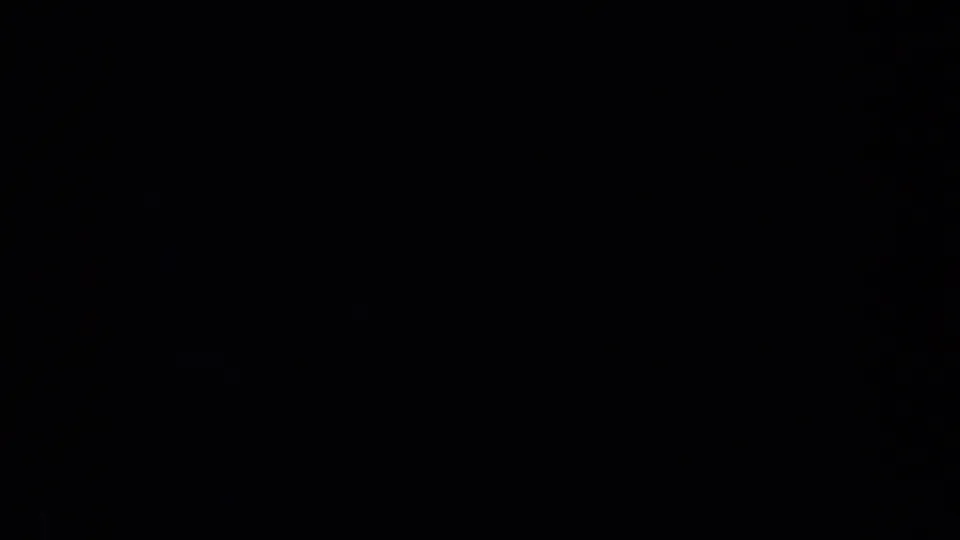 A heavily shadowed 1957 8mm frame with no clearly identifiable people, logos, or animals visible.
