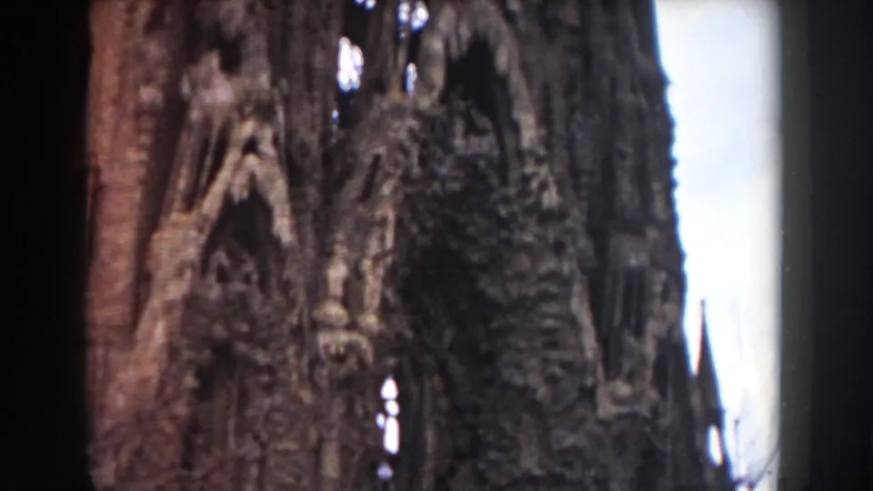 1959 Barcelona 8mm frame of Sagrada Familia facade ornament, showing carved stone texture, narrow openings, and a warm faded color cast.