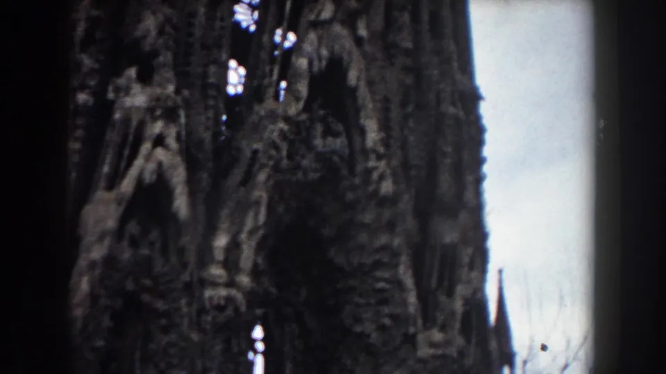 1959 Barcelona frame of a tall carved stone exterior, with narrow arched openings and small stained-glass highlights in the upper facade.