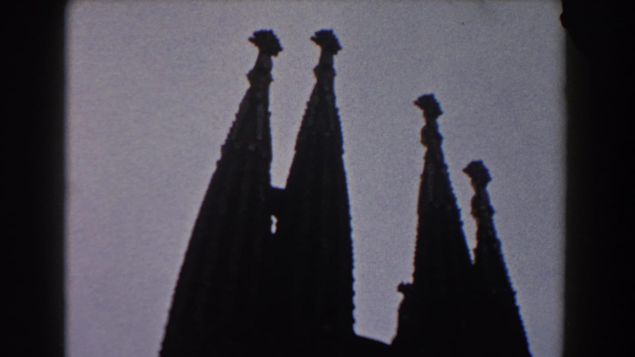 Silhouetted pointed church spires against a pale sky.